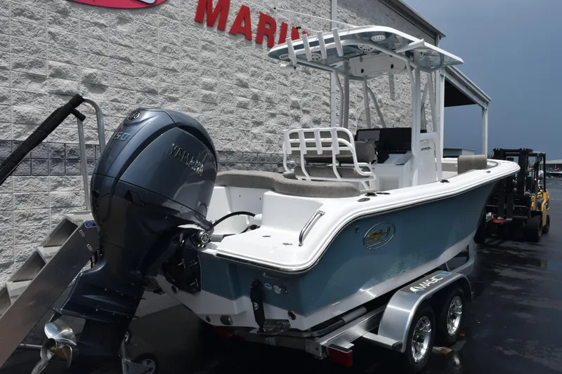 Slide: The Image of 2026 Sea Hunt Ultra 219 boat with Yamaha engine on trailer, parked outside. - 4