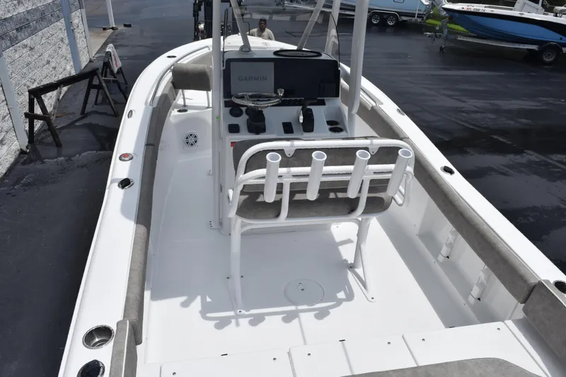 Slide: The Image of 2026 Sea Hunt Ultra 219 boat interior with console and seating, docked outdoors. - 6