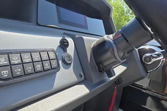 Slide: The Image of 2026 Sun Tracker PB 20 DLX dashboard with control panel and steering wheel. - 14