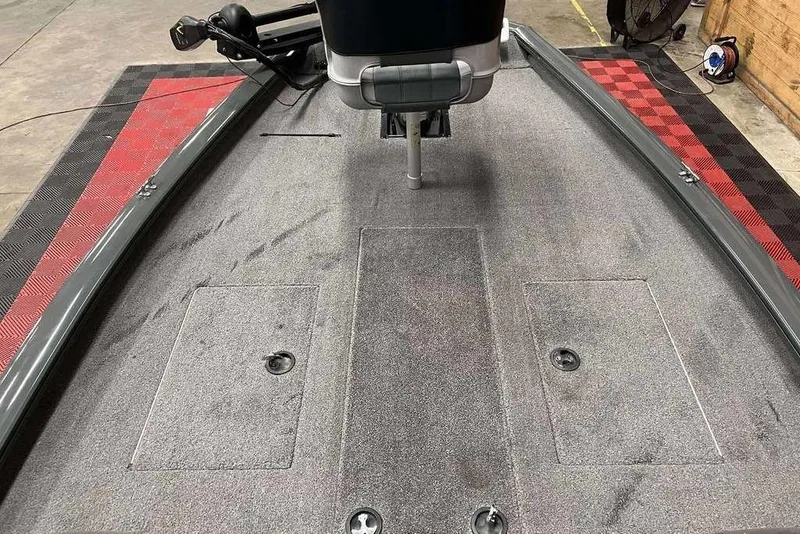 Slide: The Image of 2026 Tracker Pro Team™ 190 TX boat interior with carpeted deck and storage compartments. - 2