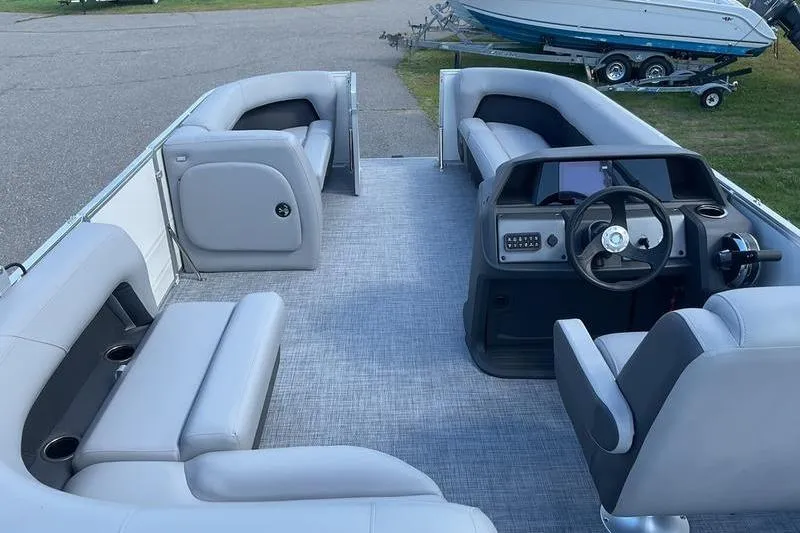 Slide: The Image of 2026 Sun Tracker PB 18 DLX pontoon boat interior with gray seating and steering console. - 11