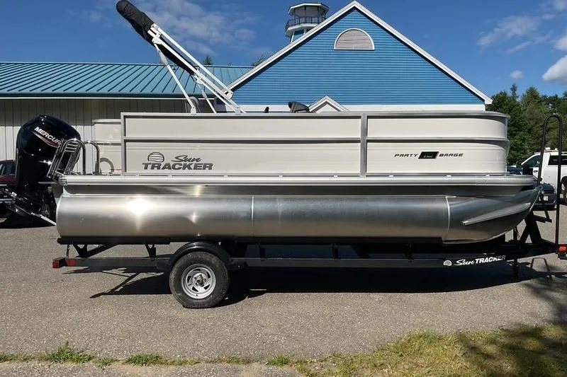Slide: The Image of 2026 Sun Tracker PB 18 DLX pontoon boat on trailer, parked outdoors. - 5