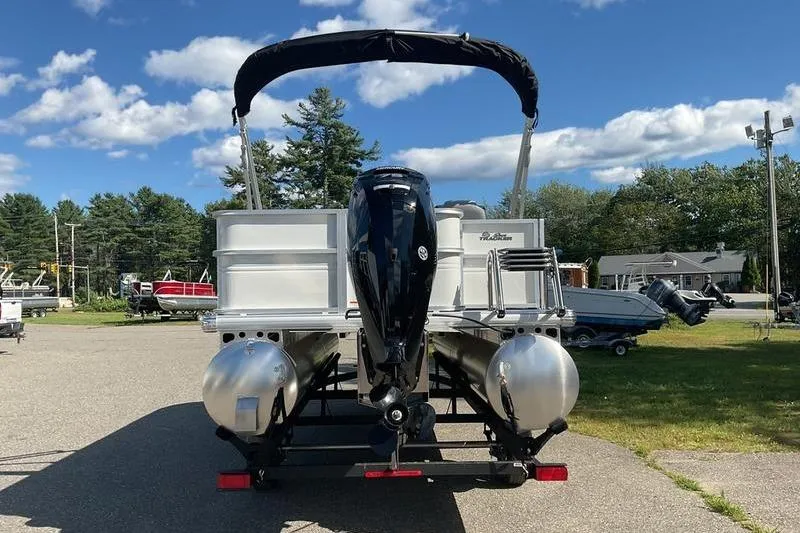 Slide: The Image of 2026 Sun Tracker PB 18 DLX pontoon boat on trailer, parked outdoors under blue sky. - 8