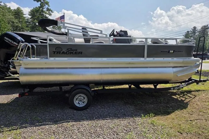 Slide: The Image of 2026 Sun Tracker BB 18 DLX pontoon boat on trailer, parked outdoors. - 4