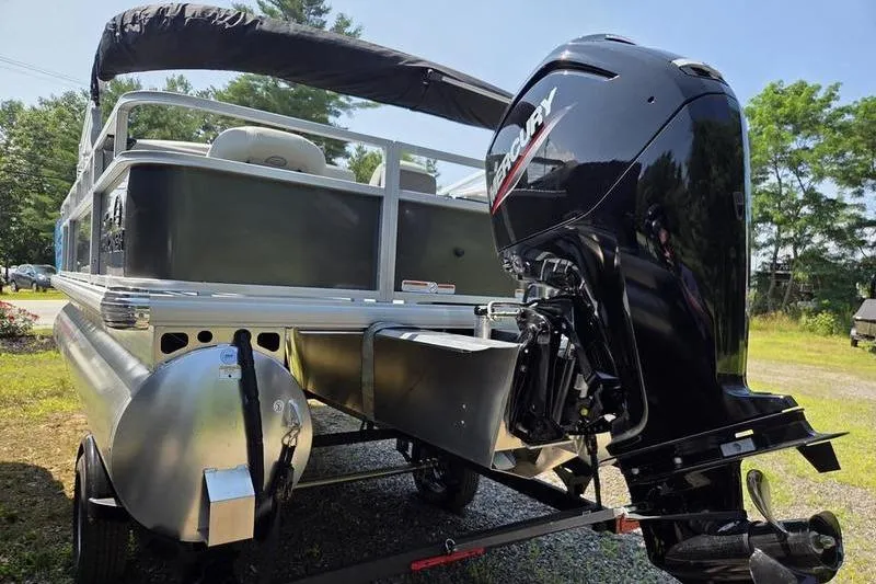 Slide: The Image of 2026 Sun Tracker BB 18 DLX pontoon boat with Mercury outboard motor, parked outdoors. - 5