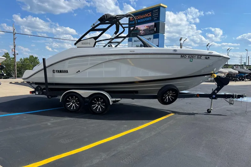 Slide: The Image of 2024 Yamaha Boats 222SE on trailer, parked outdoors under a clear blue sky. - 6