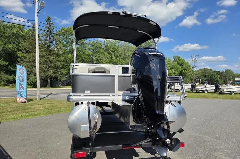 Slide: The Image of 2026 Sun Tracker BB 18 DLX pontoon boat with outboard motor, parked outdoors. - 10