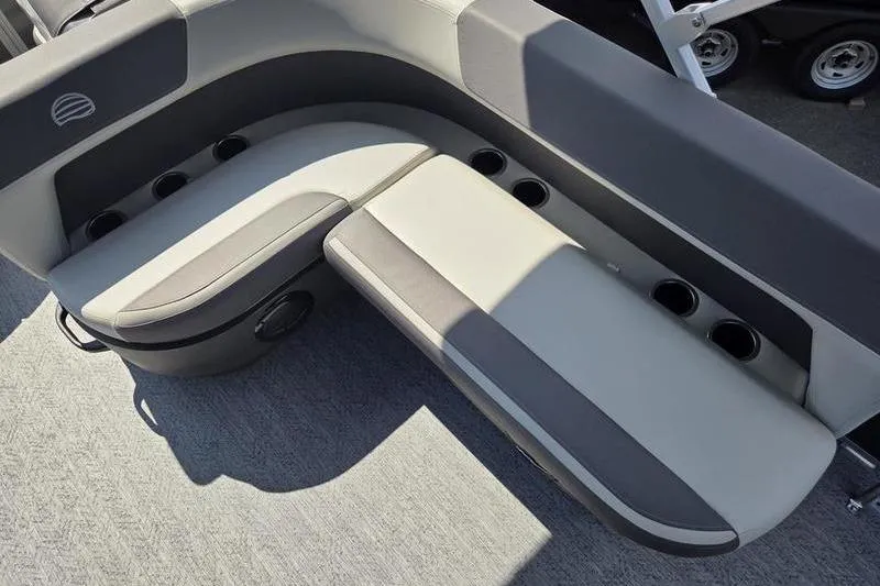 Slide: The Image of 2026 Sun Tracker BB 18 DLX boat seating with cup holders, gray upholstery, and carpeted flooring. - 3