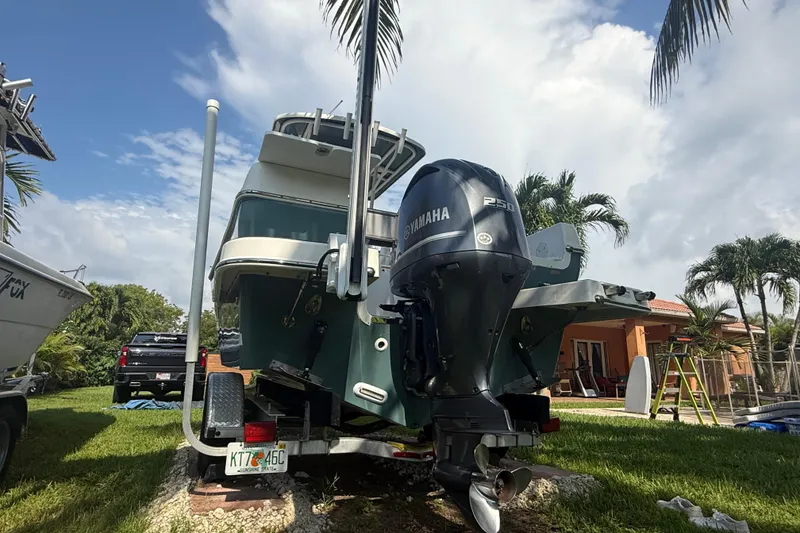 Slide: The Image of 2020 Striper 220 Center Console boat with Yamaha engine on trailer, surrounded by palm trees. - 10