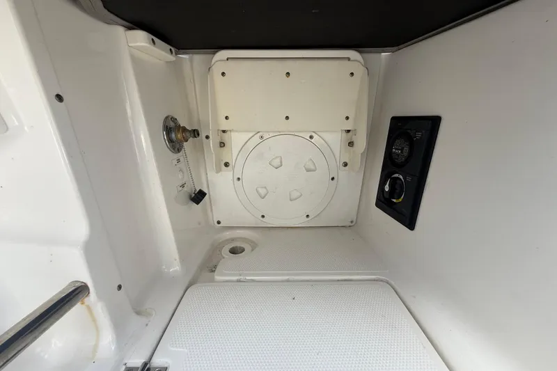 Slide: The Image of 2020 Striper 220 Center Console interior compartment with control panel and access hatch. - 23