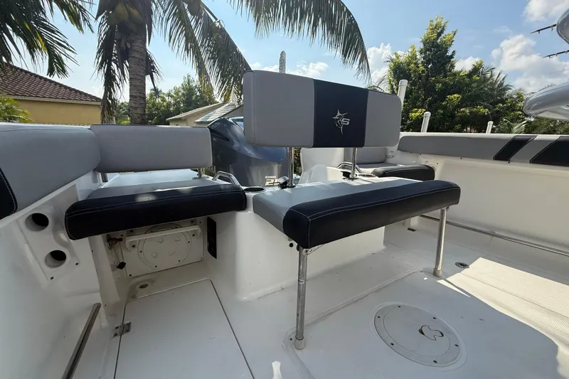 Slide: The Image of 2020 Striper 220 Center Console boat interior with seating, palm trees in background. - 25