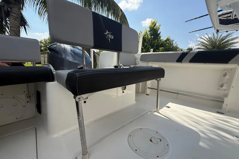 Slide: The Image of 2020 Striper 220 Center Console boat interior with seating and palm trees in the background. - 26