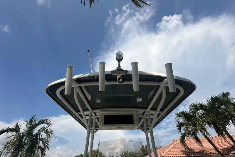 Slide: The Image of 2020 Striper 220 Center Console boat with T-top under a clear blue sky. - 27