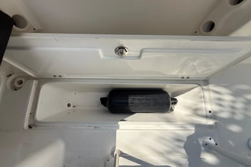 Slide: The Image of 2020 Striper 220 Center Console storage compartment with a black fender inside. - 52