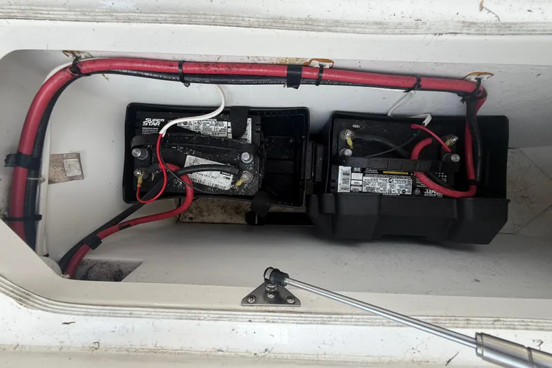 Slide: The Image of 2020 Striper 220 Center Console boat battery compartment with wiring and dual batteries. - 57