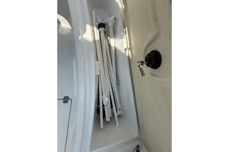 Slide: The Image of Storage compartment in a 2020 Striper 220 Center Console boat, featuring fishing gear. - 58