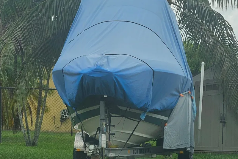 Slide: The Image of Covered 2020 Striper 220 Center Console boat on trailer, surrounded by palm trees. - 64
