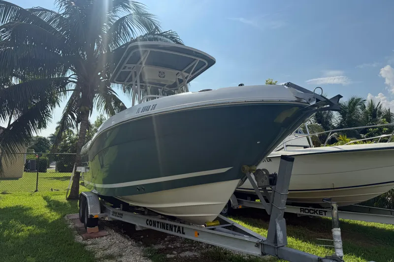Slide: The Image of 2020 Striper 220 Center Console boat on trailer, parked near palm trees. - 8