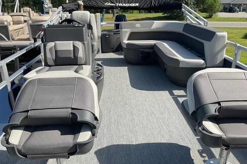 Slide: The Image of 2026 Sun Tracker BB 18 DLX pontoon boat interior with gray seating and steering console. - 10