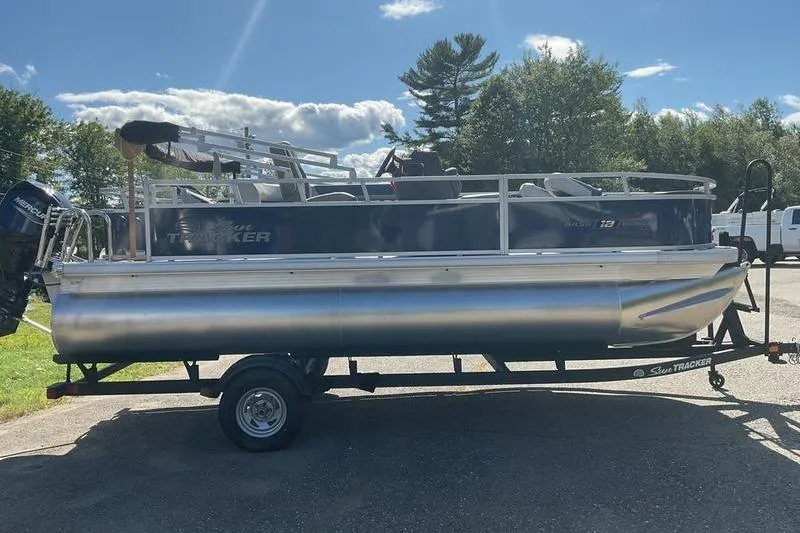 Slide: The Image of 2026 Sun Tracker BB 18 DLX pontoon boat on trailer, parked outdoors under a sunny sky. - 8