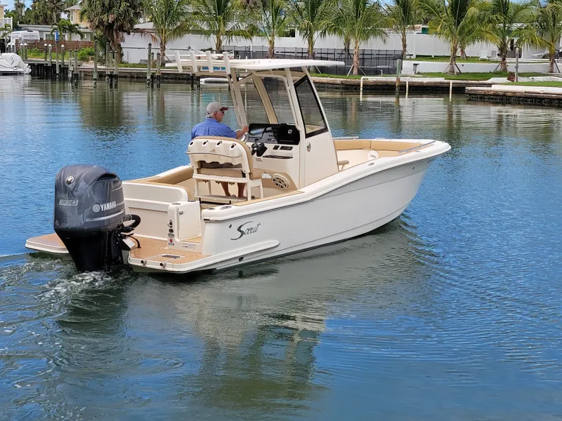 Slide: The Image of 2018 Scout 235XSF boat with Yamaha engine cruising on a calm waterway. - 1