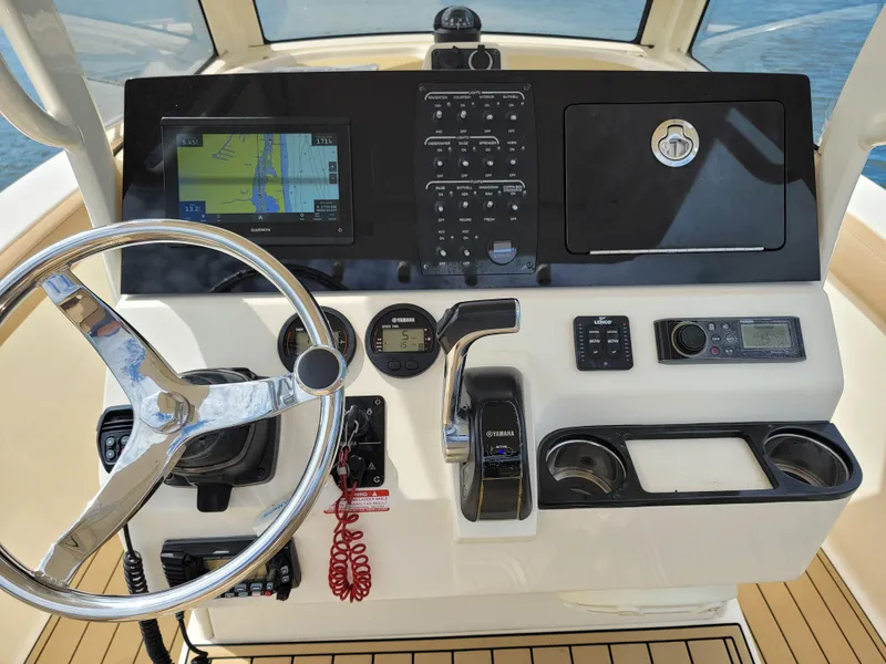 Slide: The Image of 2018 Scout 235XSF boat dashboard with steering wheel, navigation system, and control panel. - 3