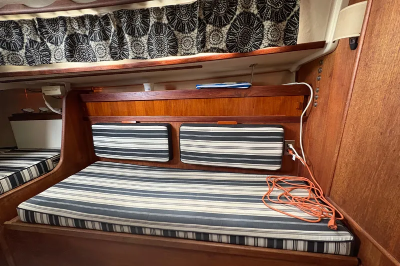 Slide: The Image of Interior of 1981 Sabre 31 sailboat with striped cushions and wooden paneling. - 100