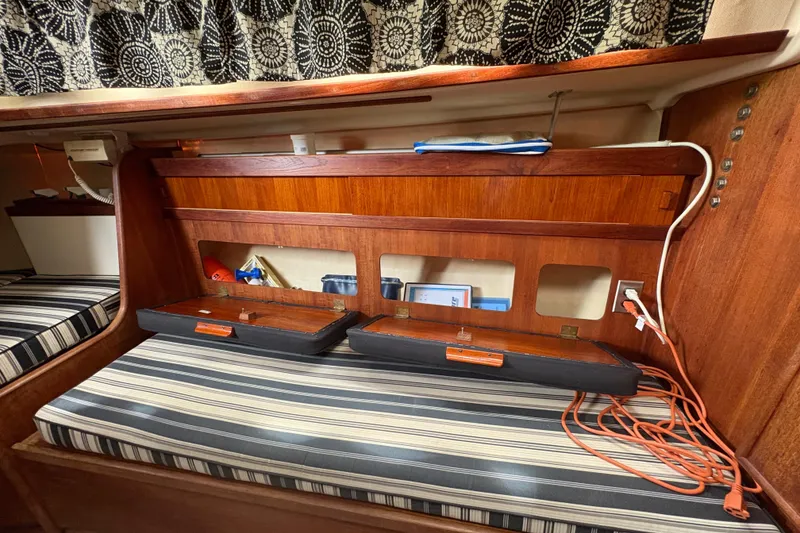 Slide: The Image of Interior of 1981 Sabre 31 sailboat with striped cushions and wooden storage compartments. - 102