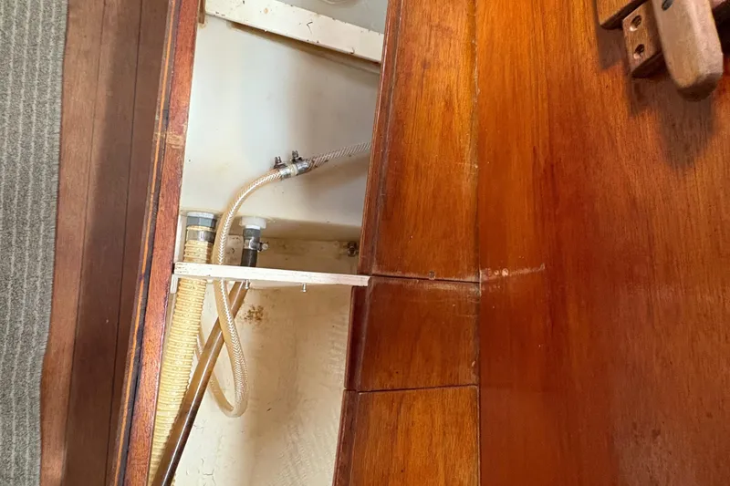 Slide: The Image of Interior view of 1981 Sabre 31 sailboat showing wooden cabinetry and plumbing hoses. - 105
