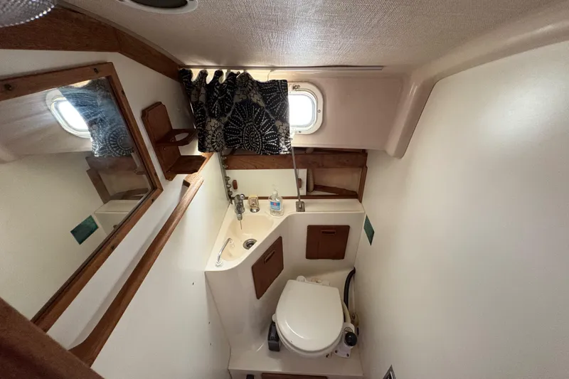 Slide: The Image of Compact bathroom in 1981 Sabre 31 sailboat with mirror, sink, and toilet. - 119
