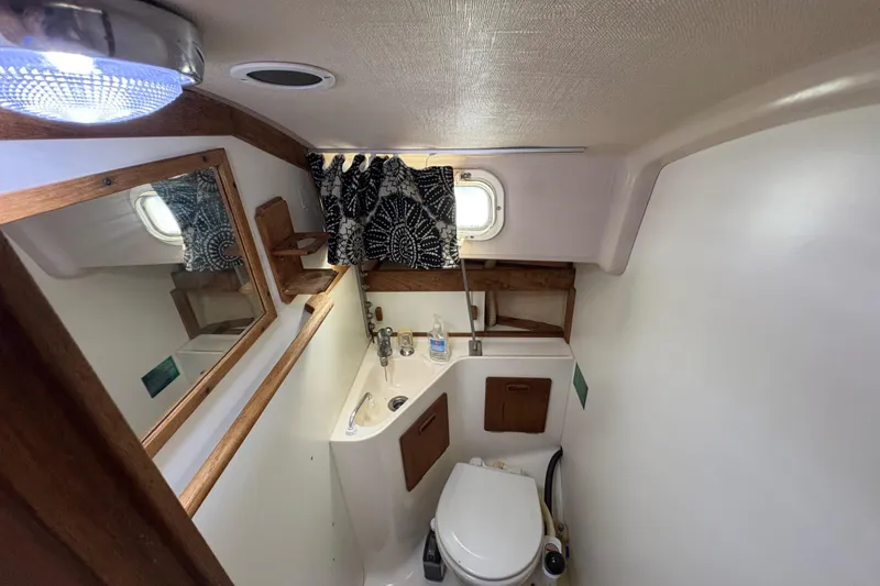 Slide: The Image of 1981 Sabre 31 yacht bathroom with sink, toilet, mirror, and window. - 120