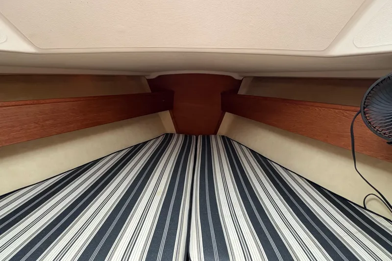 Slide: The Image of Interior cabin of a 1981 Sabre 31 sailboat with striped bedding and wooden accents. - 122