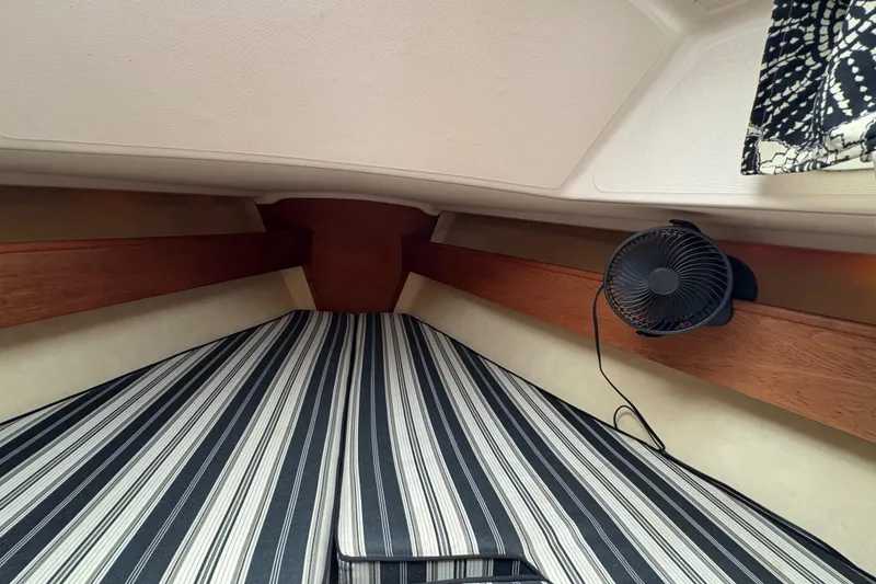 Slide: The Image of Interior of 1981 Sabre 31 sailboat with striped bedding and a small fan. - 123