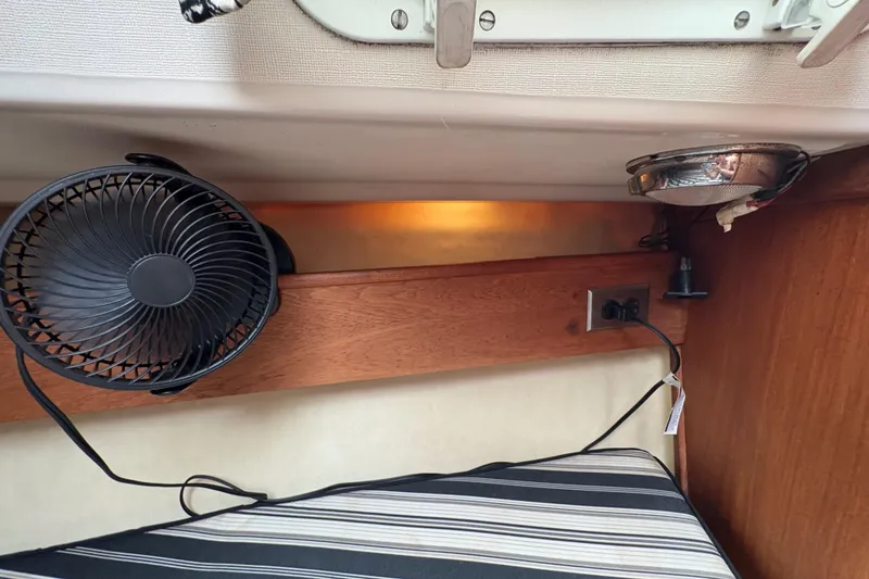 Slide: The Image of 1981 Sabre 31 interior with fan, striped cushion, and electrical outlet. - 125