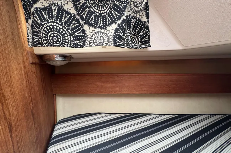 Slide: The Image of Interior of a 1981 Sabre 31 sailboat with patterned curtain and striped cushion. - 126