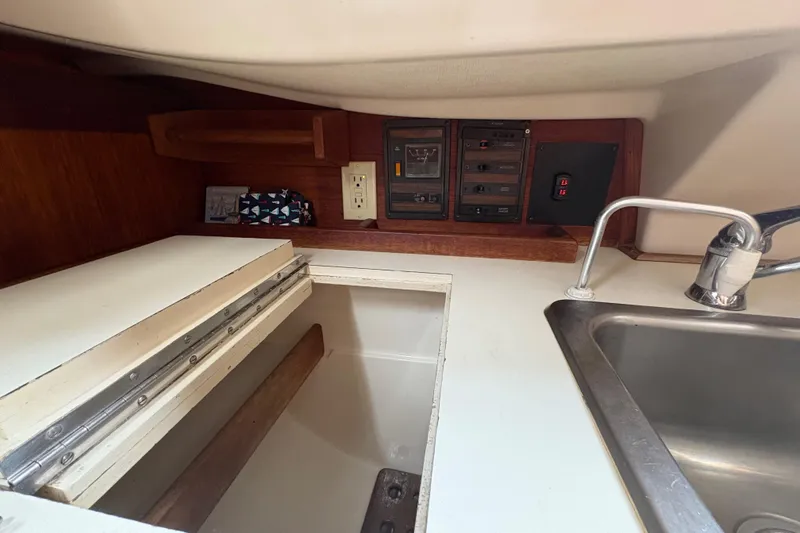 Slide: The Image of 1981 Sabre 31 yacht interior with sink, control panel, and storage area. - 130