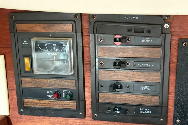 Slide: The Image of Electrical panel of a 1981 Sabre 31 sailboat with AC power controls and voltmeter. - 132