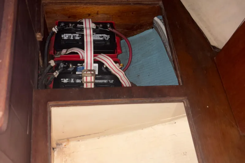 Slide: The Image of Battery compartment in a 1981 Sabre 31 sailboat, featuring secured dual batteries. - 145