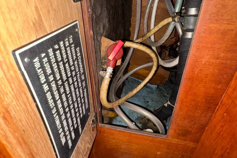 Slide: The Image of Interior view of a 1981 Sabre 31 sailboat showing hoses and a warning sign. - 146
