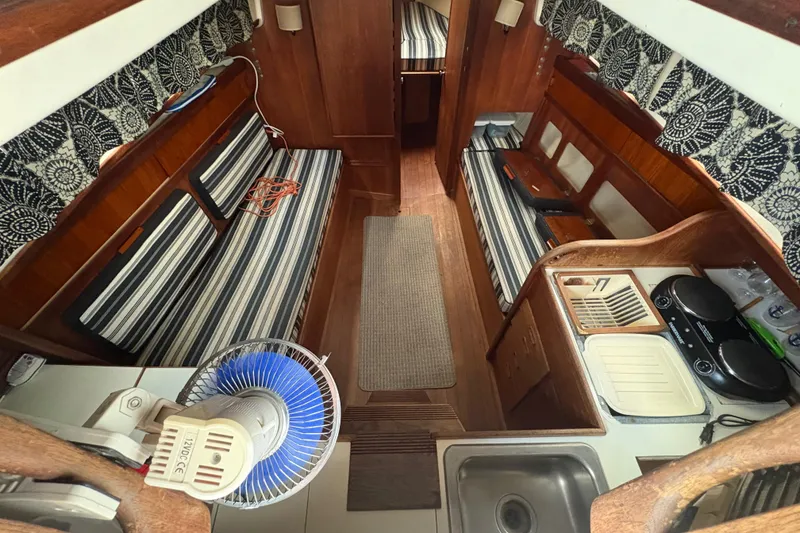 Slide: The Image of Interior of a 1981 Sabre 31 sailboat with striped seating and compact kitchen area. - 15