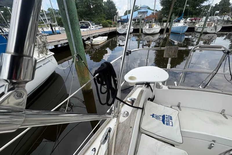 Slide: The Image of 1981 Sabre 31 sailboat docked at marina, featuring cockpit and surrounding boats. - 49