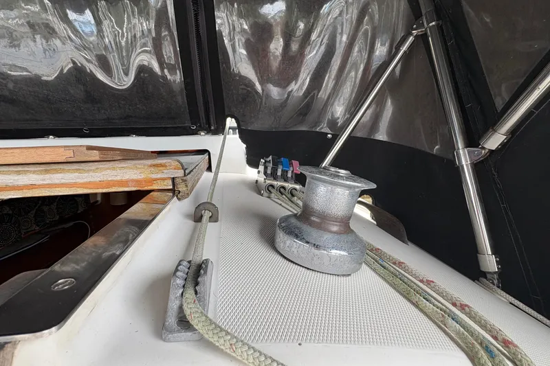 Slide: The Image of 1981 Sabre 31 sailboat deck with winch, ropes, and cabin entrance. - 55