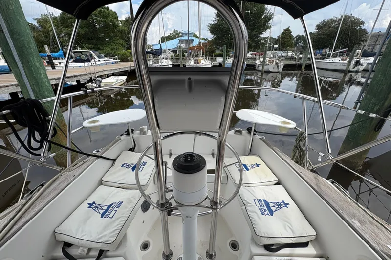 Slide: The Image of Cockpit of a 1981 Sabre 31 sailboat docked at a marina, featuring cushioned seating. - 56