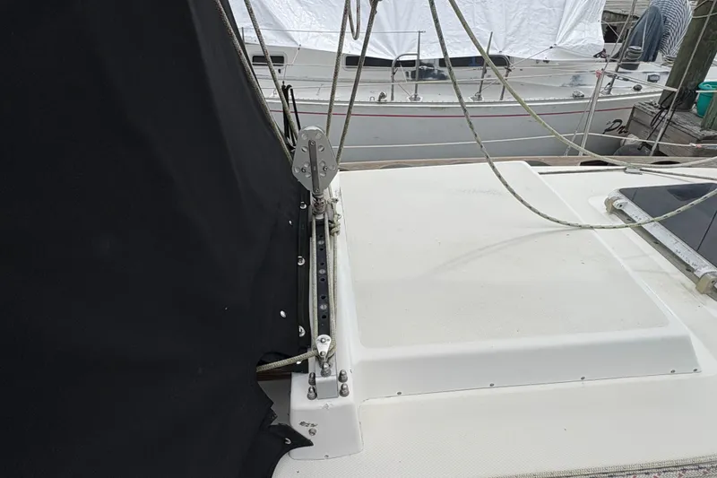 Slide: The Image of 1981 Sabre 31 sailboat deck with rigging and black cover, docked beside another boat. - 66
