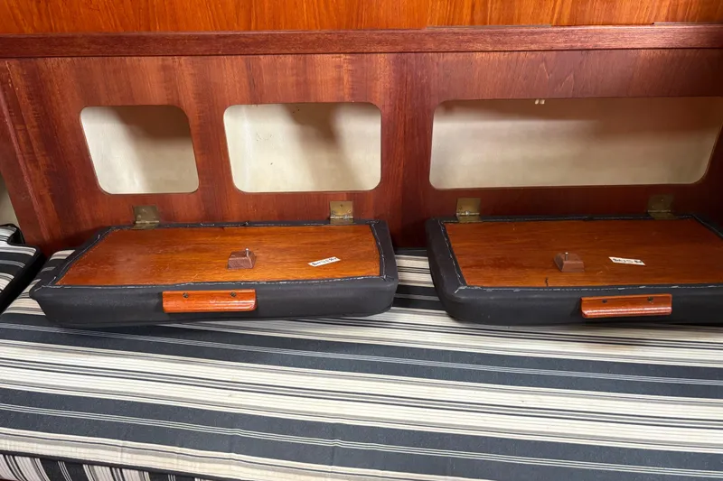 Slide: The Image of Interior of 1981 Sabre 31 sailboat with wooden storage compartments and striped cushion. - 80