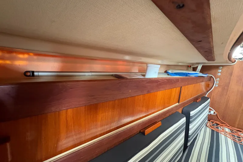 Slide: The Image of Interior of 1981 Sabre 31 sailboat with wooden paneling and striped cushions. - 86