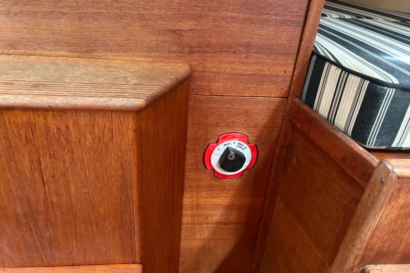 Slide: The Image of Wooden interior of 1981 Sabre 31 boat with a battery switch and striped cushion. - 89