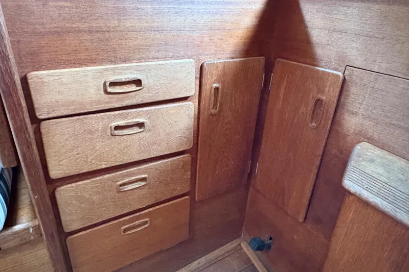 Slide: The Image of Wooden cabinetry inside a 1981 Sabre 31 sailboat, featuring drawers and cupboards. - 90