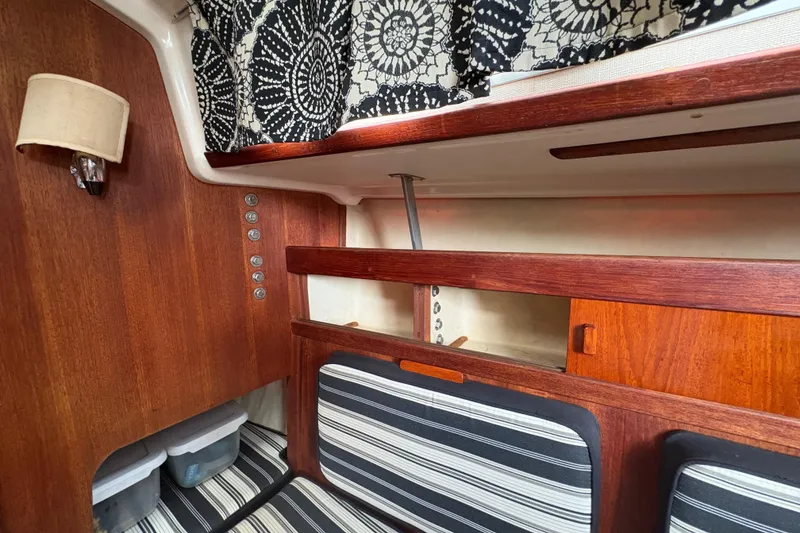Slide: The Image of Interior of a 1981 Sabre 31 sailboat with wood paneling and striped cushions. - 97