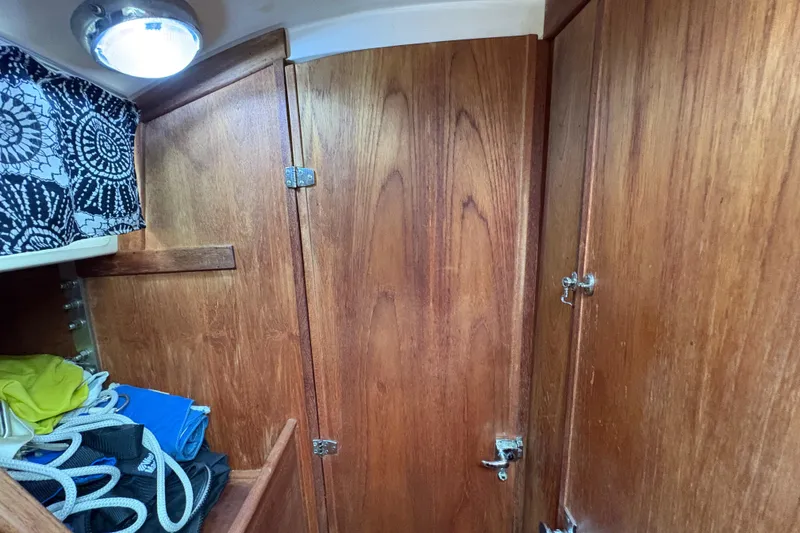 Slide: The Image of Interior of a 1981 Sabre 31 sailboat with wood paneling and striped cushions. - 23